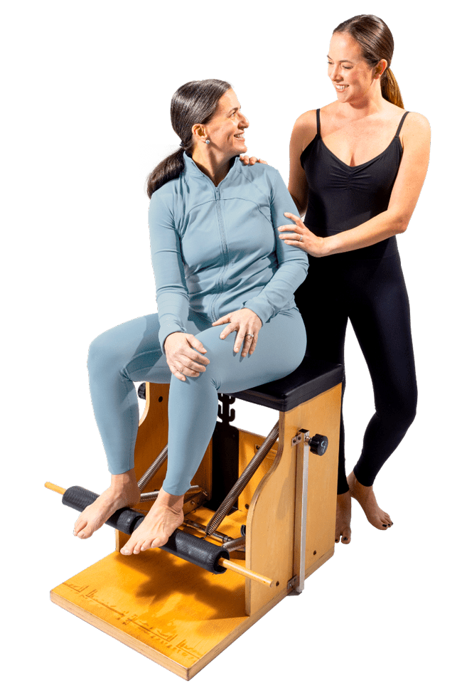 Pilates instructor and student training on Pilates chair